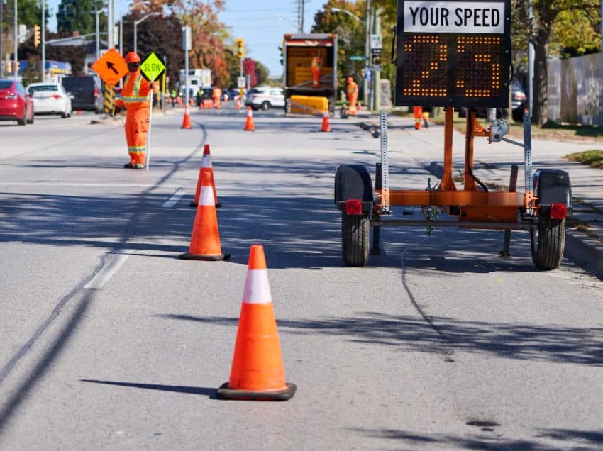 Flagger, cones and a speed trailer on a lane closure
