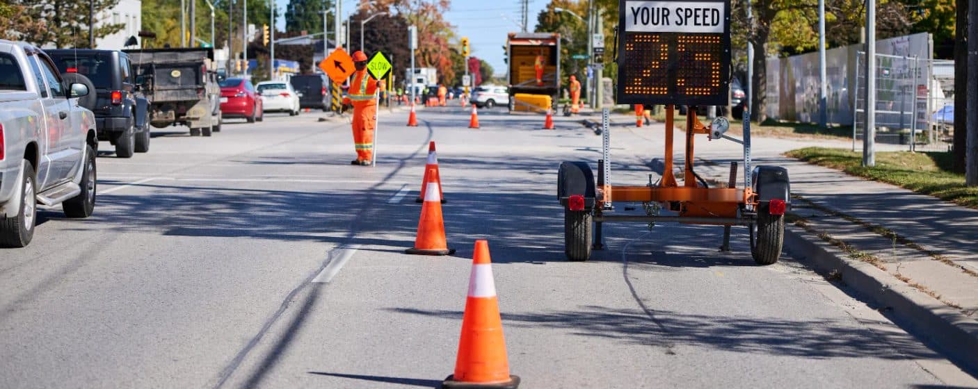 Flagger, cones and a speed trailer on a lane closure